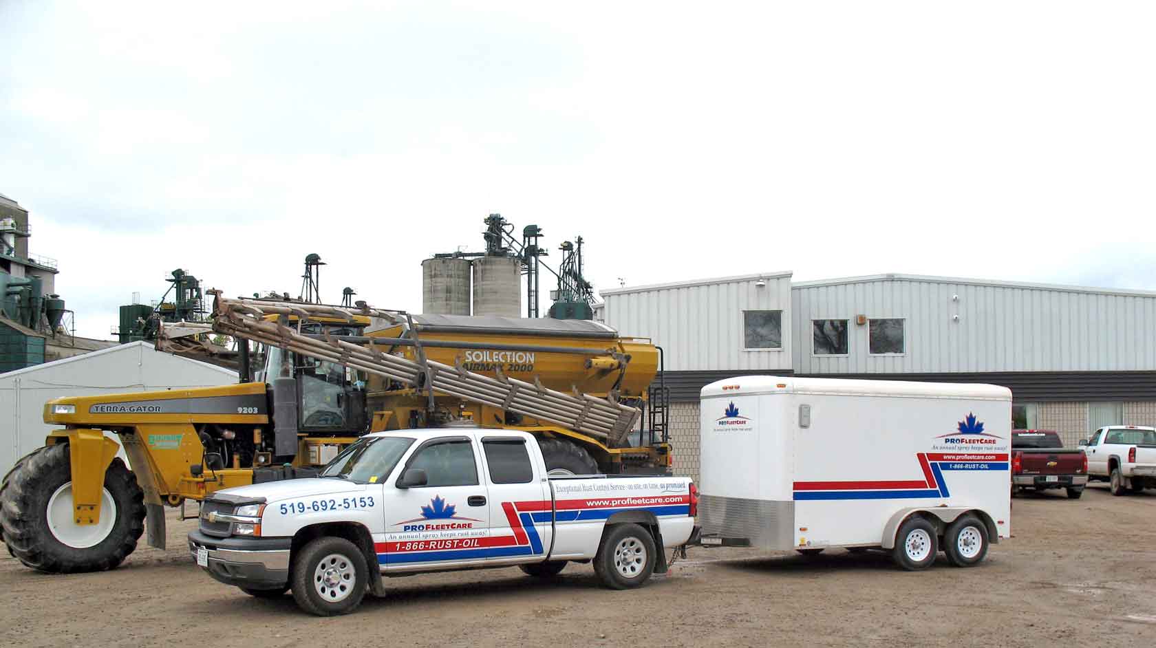 Branded Pro Fleet Care truck and mobile service trailer beside agricultural equipment